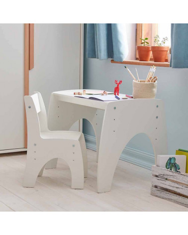 Petite table réglable blanche dans une chambre bébé avec chaise